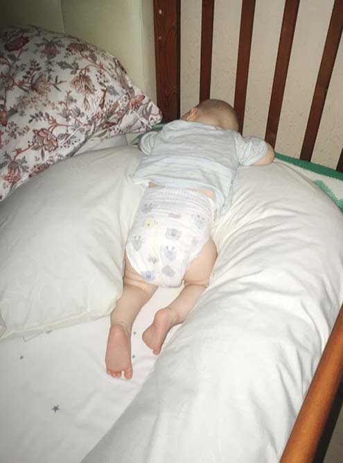 Сын спит уже в своей кроватке, которая приставлена к нашей. Валик для тесноты я сначала сделала из подушки для беременных