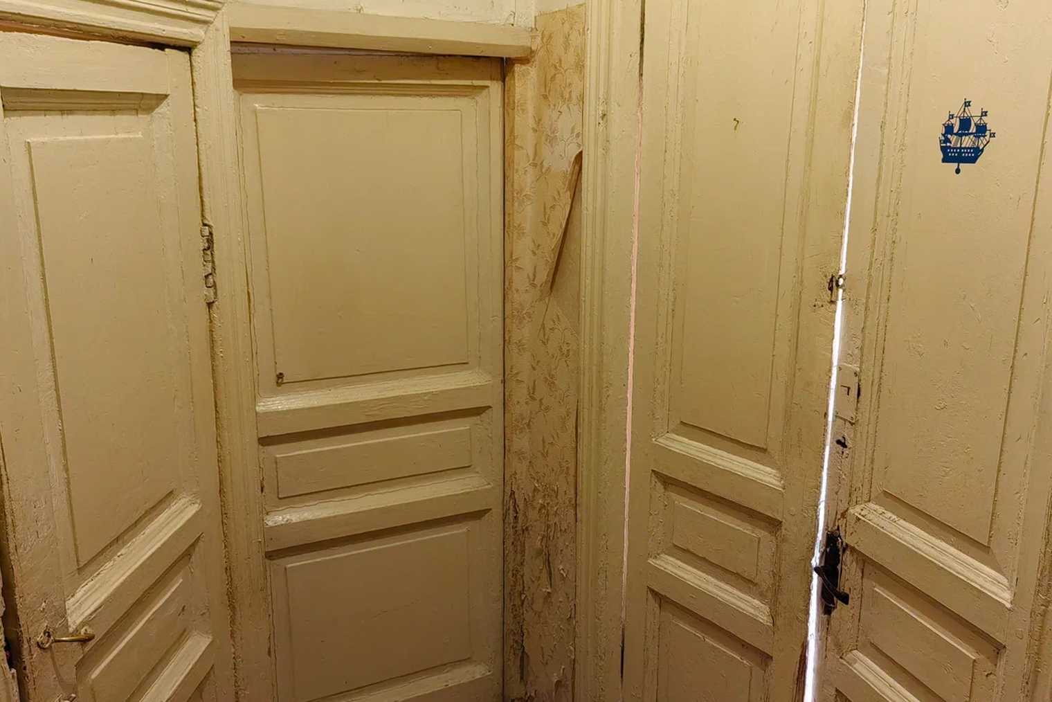 Старые двери: двойная ведет в гостиную, в центре — на кухню, а слева — в туалет. Раньше справа от гостиной была еще одна дверь, и это не считая того, что рядом еще и входная в саму квартиру