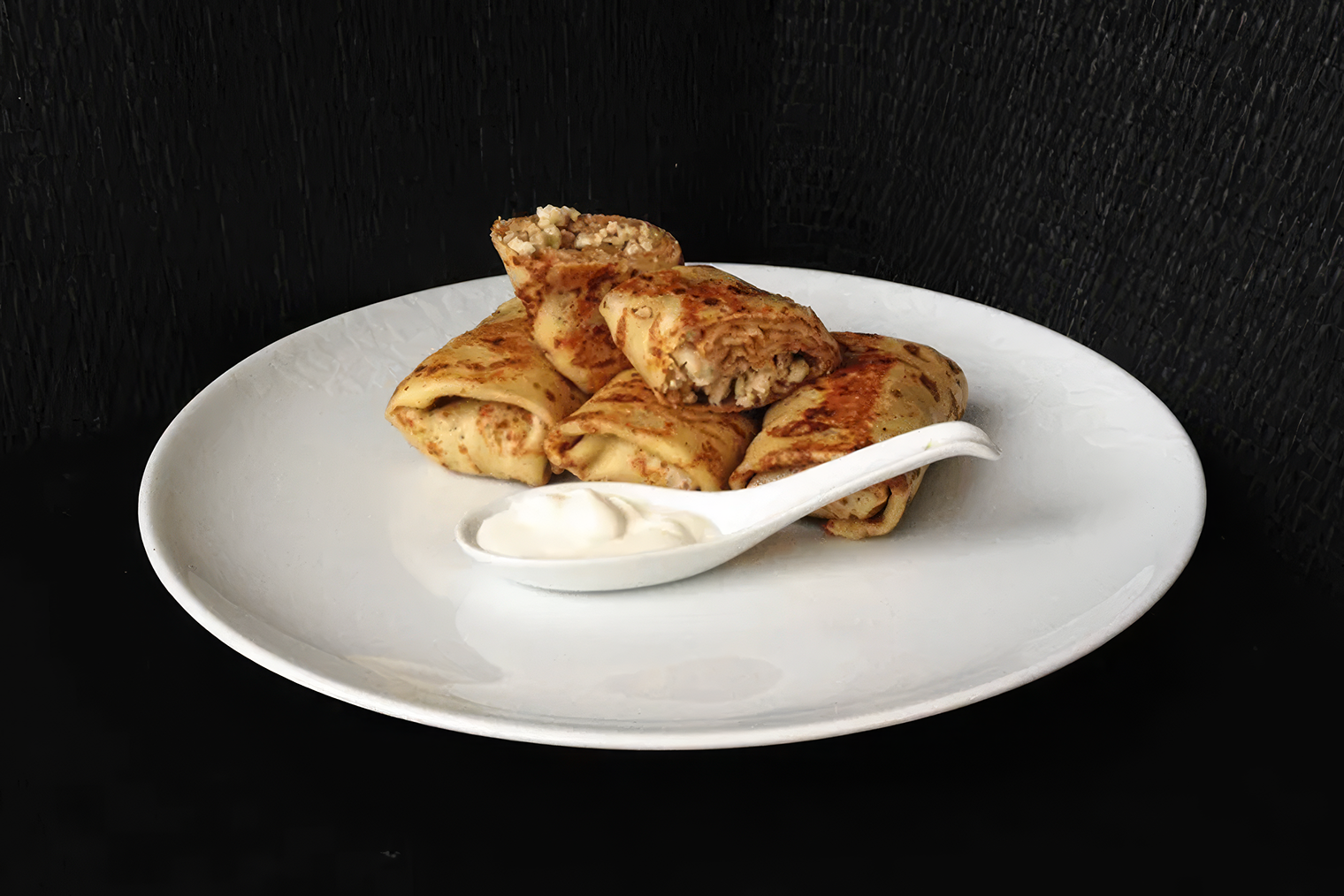Готовые блины с курицей. Куриная начинка может быть суховата, особенно если вы хорошо ее пожарили, зато блин с ней не размокнет. Более мягкую текстуру блюду придаст сметана или другой сливочный соус