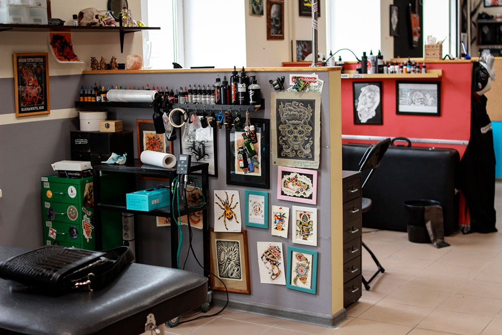 Рабочее место мастера татуировки оборудовано кушеткой, полками для хранения красок, оборудования, инструментов и расходных материалов. Мастера украшают рабочие места своими картинами, игрушками и другими памятными вещами