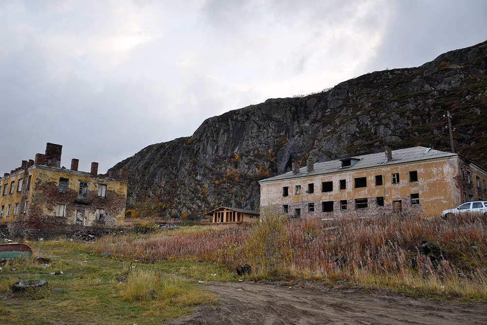 Заброшенные дома, расположенные прямо у скал, — немые свидетельства того, как непросто жить на Крайнем Севере