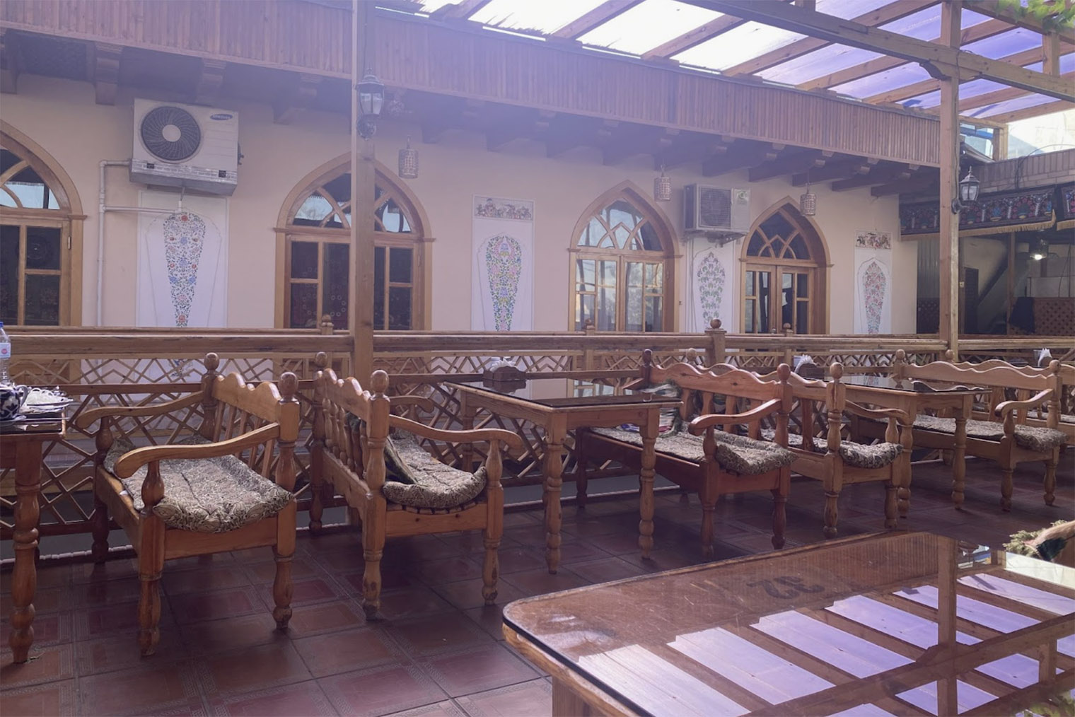 Терраса в кафе Chinar с деревянными диванчиками в национальном стиле