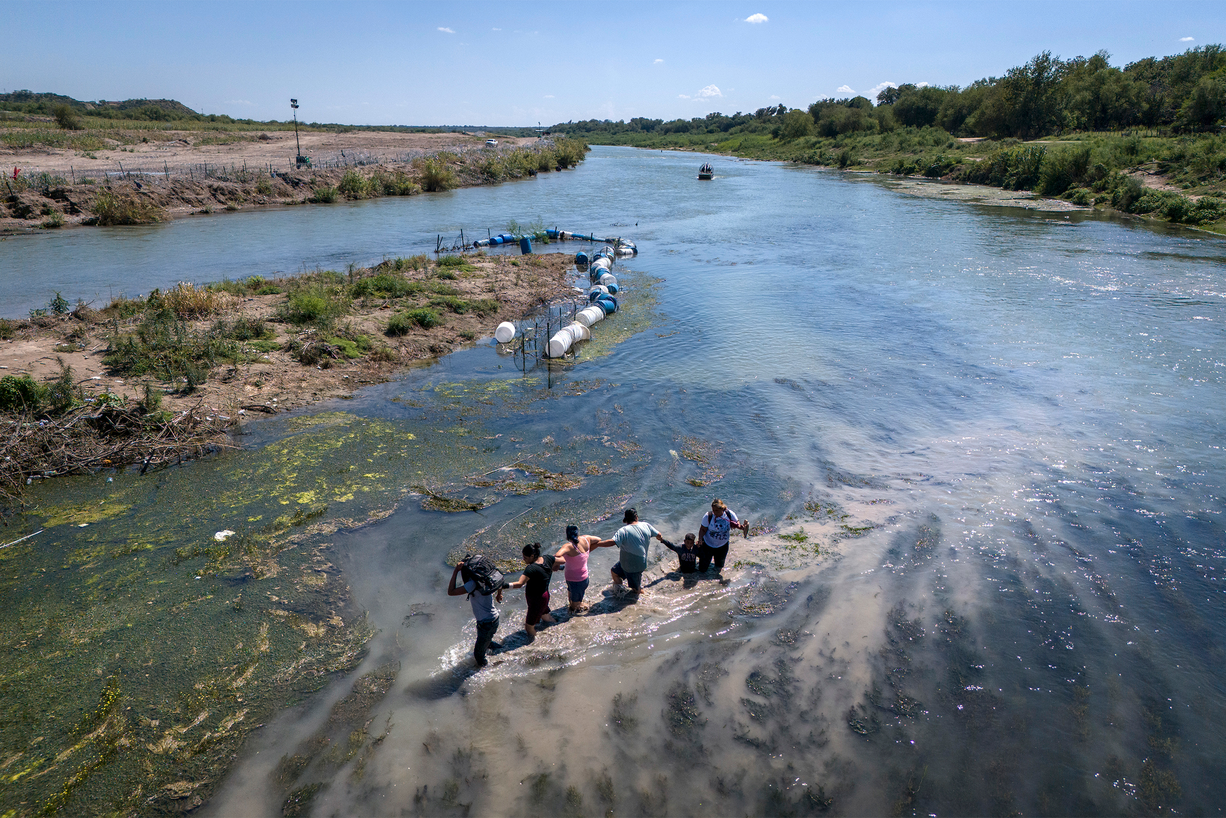Мигранты переходят вброд реку Рио⁠-⁠Гранде, разделяющую Мексику и США. Фотография: John Moore / Getty Images