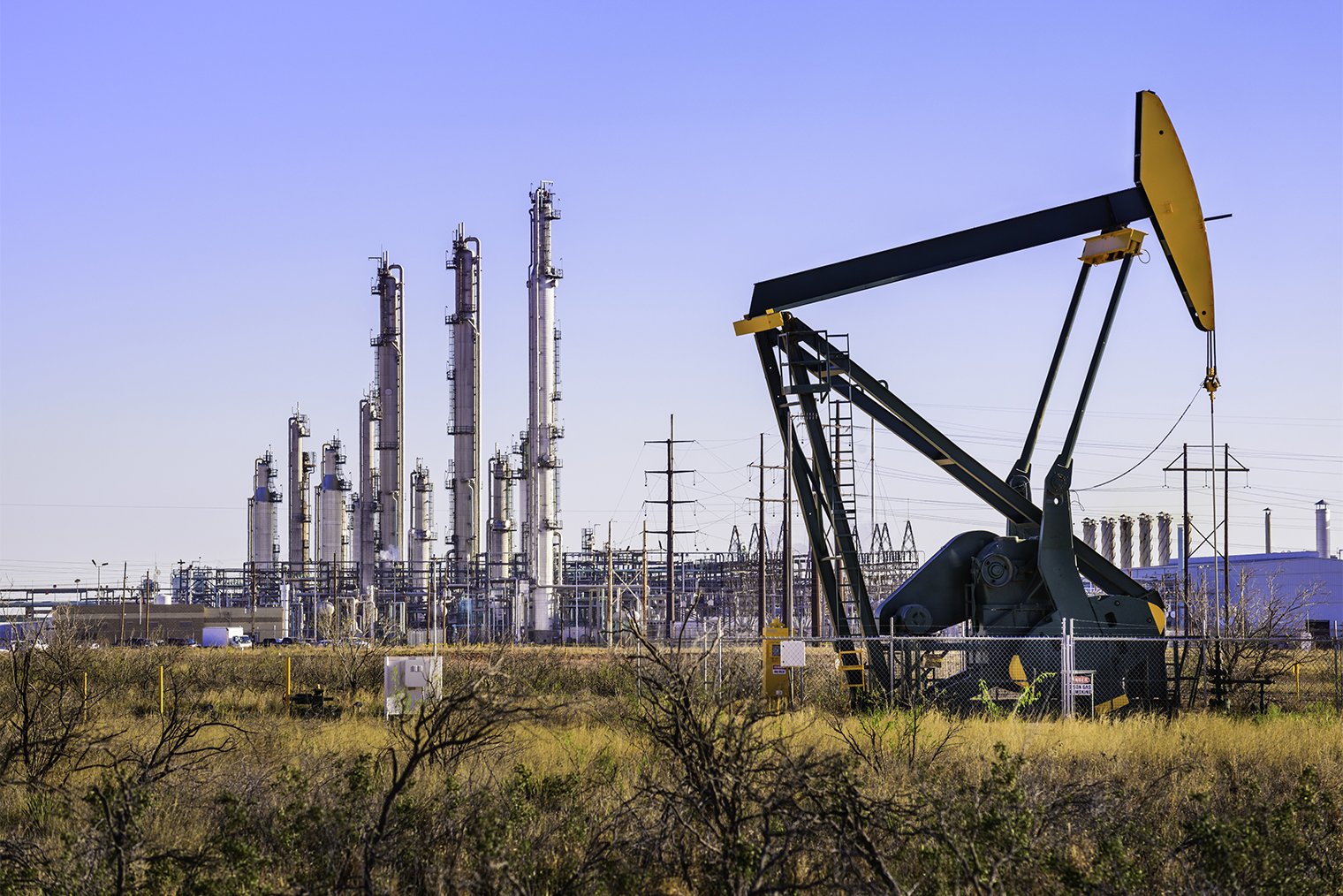 Нефтяная вышка и нефтеперерабатывающий завод в Западном Техасе. Фотография: dszc / Getty Images