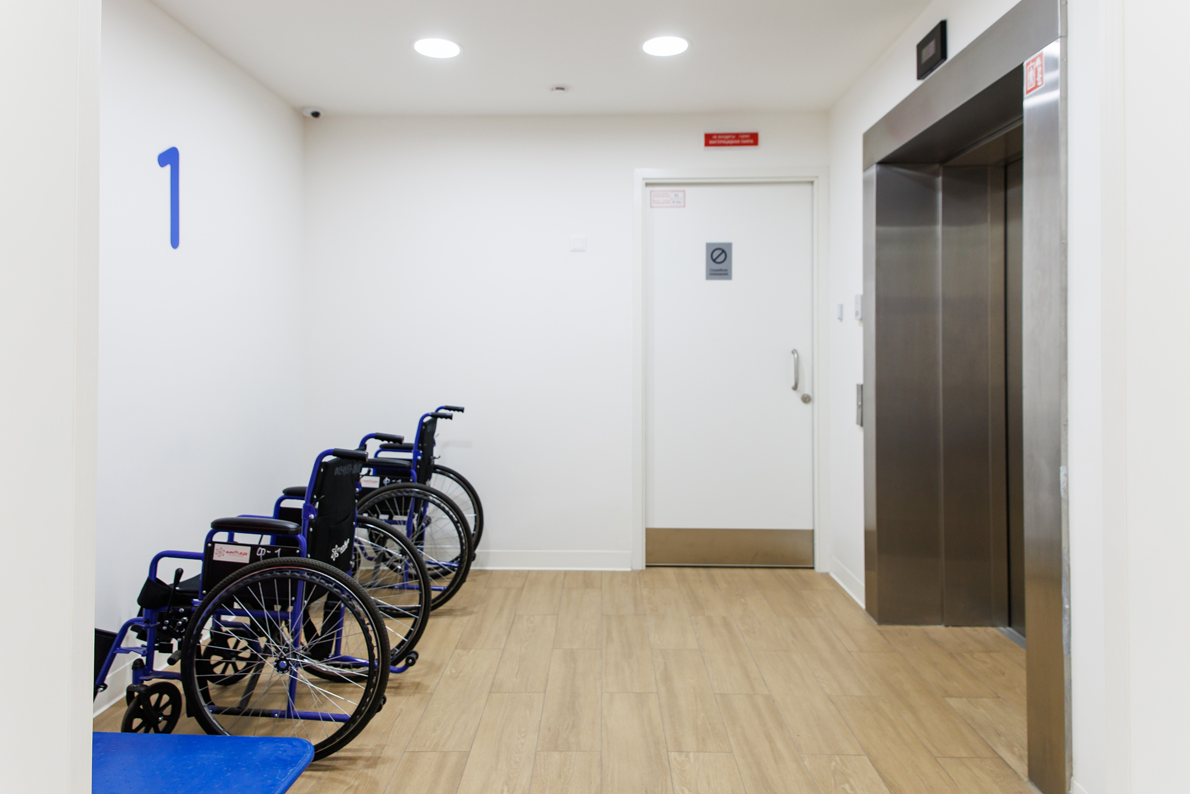 Инвалидные коляски стоят возле грузового лифта