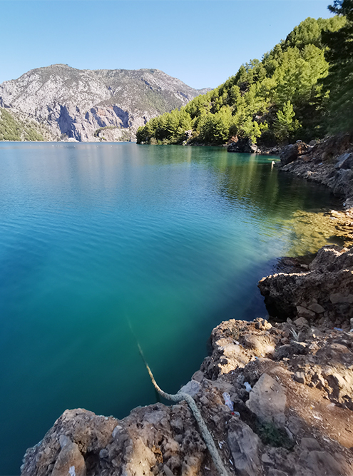 Вода в озере прозрачная и меняет цвет от зеленого до синего в зависимости от того, как падают лучи солнца. Страшно смотреть, как глубоко под воду уходят скалы и веревка