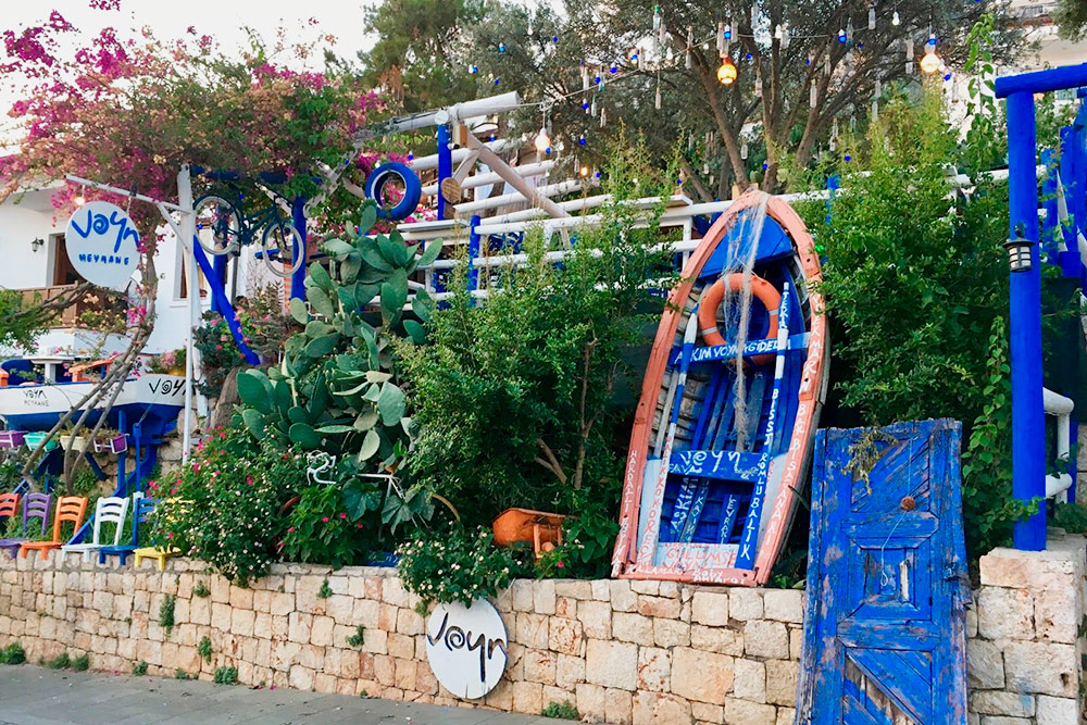 Очарование города — в деталях: разноцветных фонариках и традиционных турецких оберегах, развешанных на деревьях, старой лодке, установленной на углу семейного ресторанчика