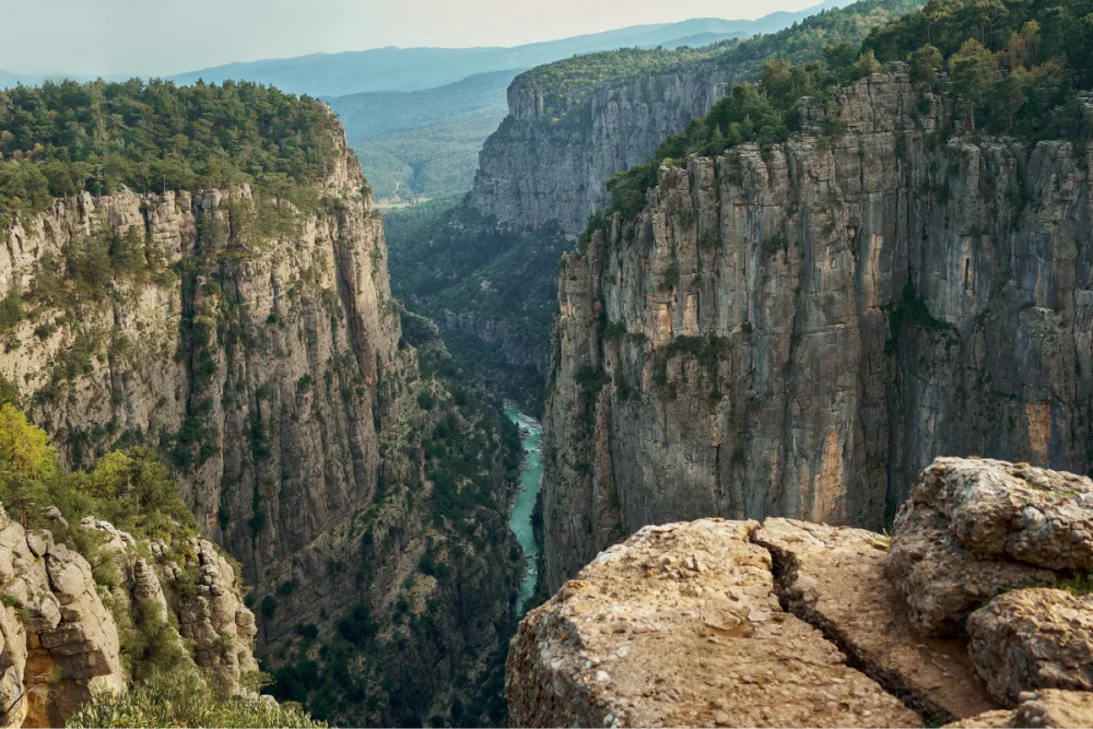 По дну каньона протекает узкая река с водой бирюзового цвета. Фото: Vitalii Matokha / Shutterstock