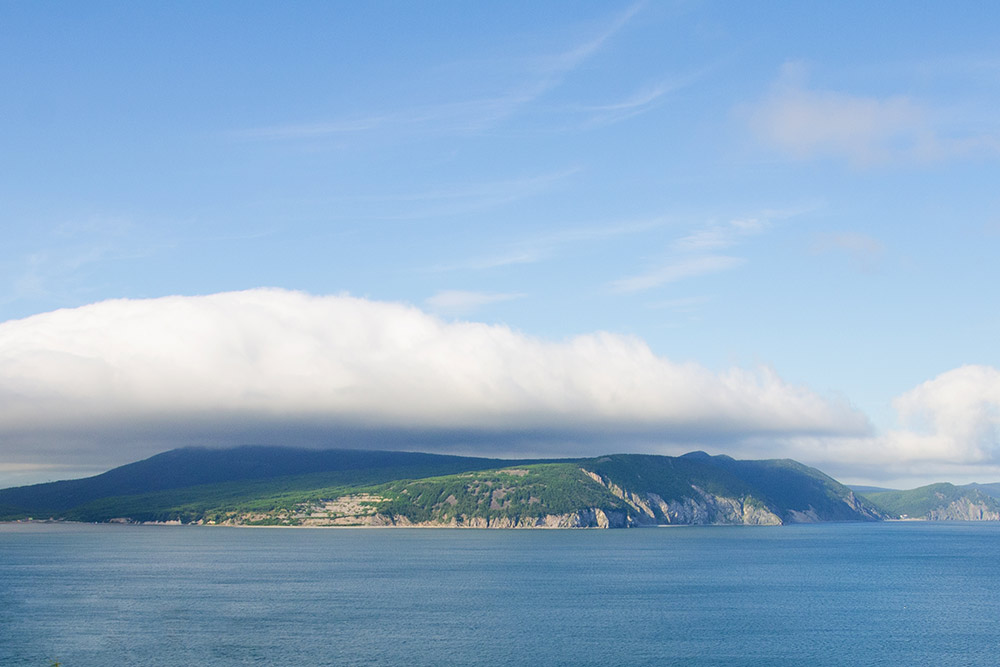 Туман над городом — это испаряющаяся вода из Охотского моря. Она конденсируется в большие облака, которые накрывают город. На фото такое облако нависло над районом Горняк — он слева между сопок — в этом месте расположен официальный городской пляж