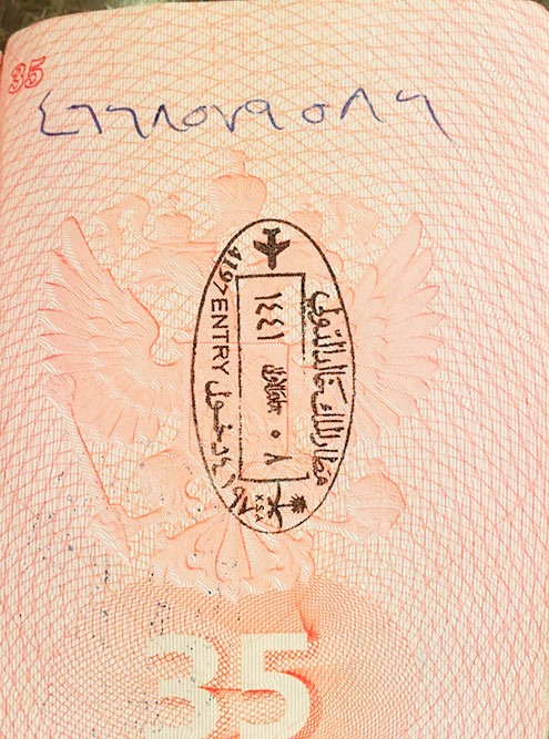 На паспортном контроле офицер ставит в паспорт штамп и ручкой записывает номер визы — так выглядят «настоящие» арабские цифры
