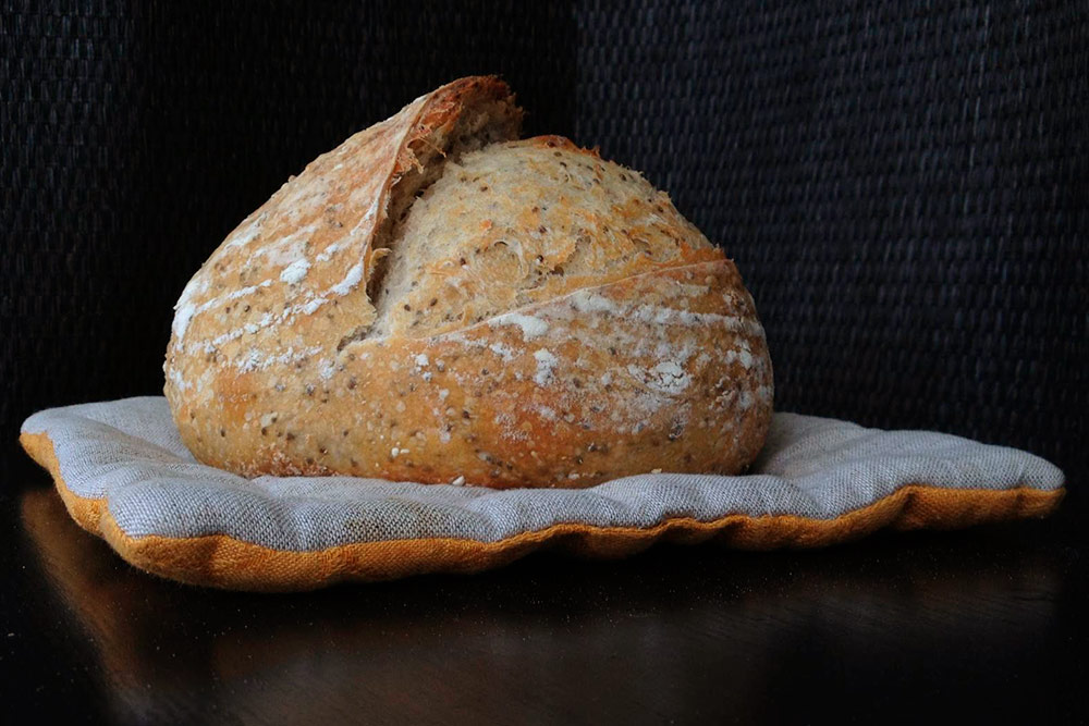 Хлеб «Кармен» на закваске с семенами чиа и цельнозерновой мукой. Это хлеб я расстаивала без чехла, благодаря этому на нем остался красивый рисунок от ротанговых прутьев