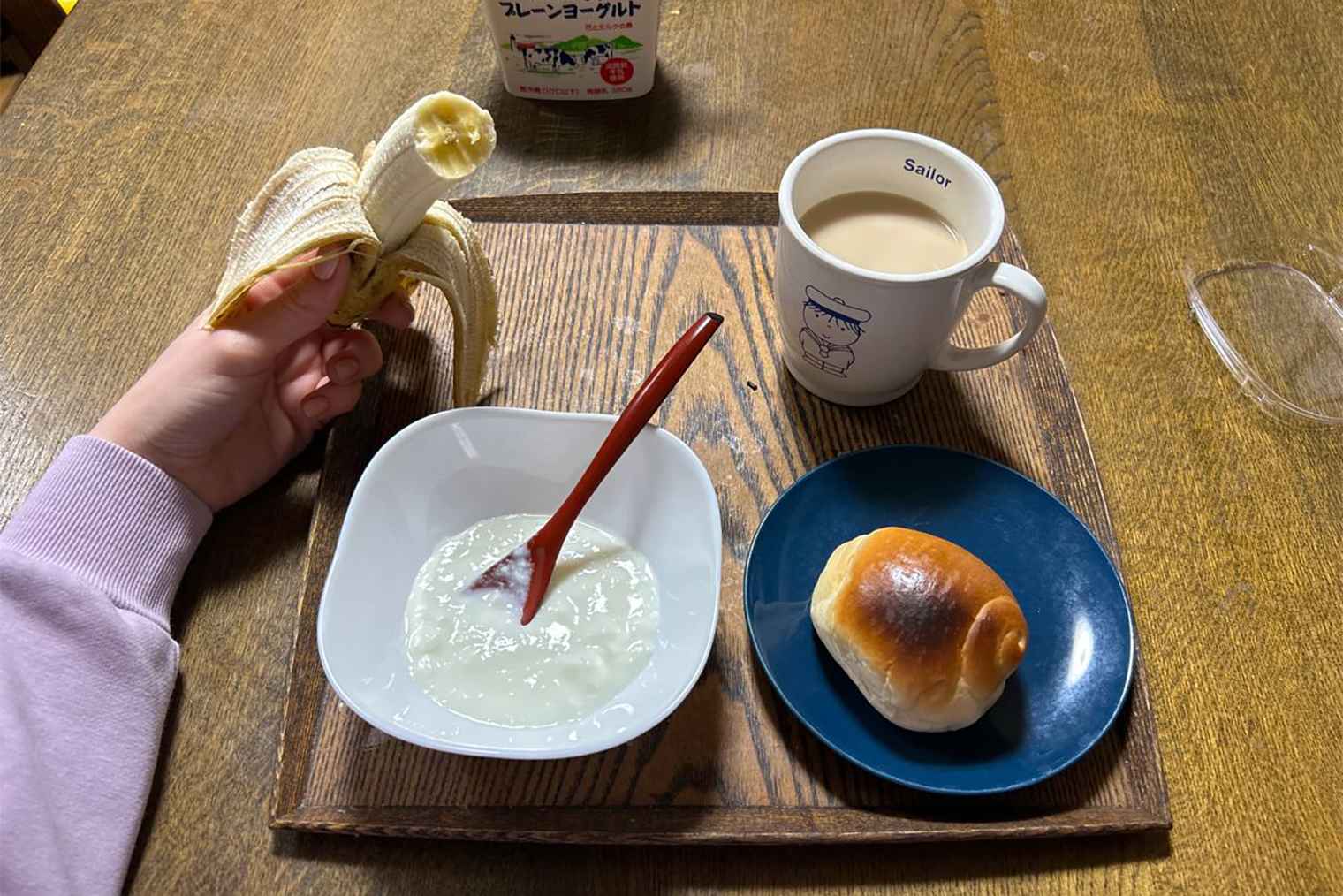 Завтрак в семье: йогурт без добавок, булочка, банан и кофе