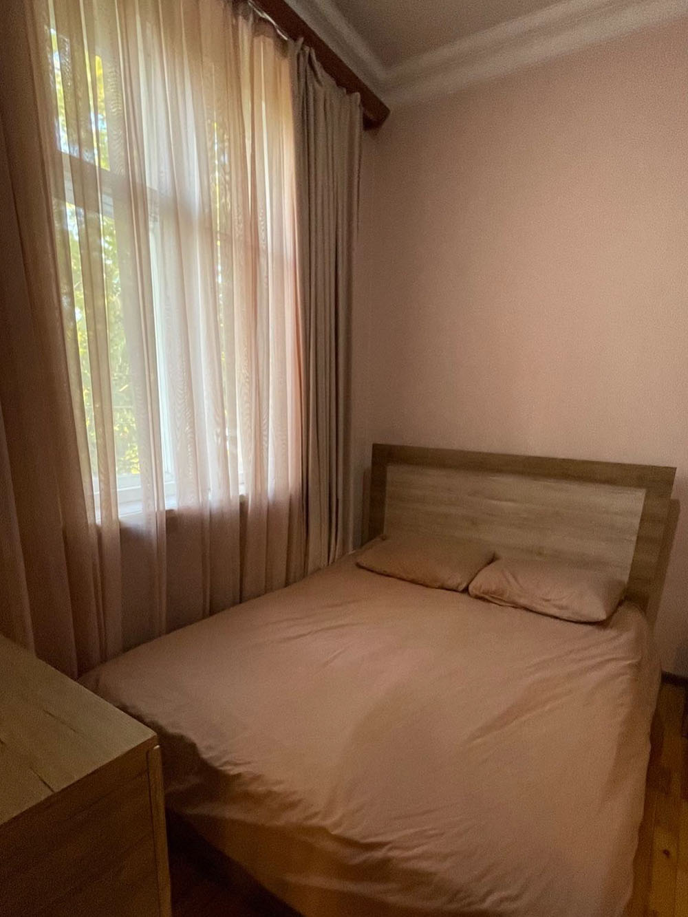 Спальня с комодом и зеркалом, справа — прикроватный столик и встроенный шкаф для одежды