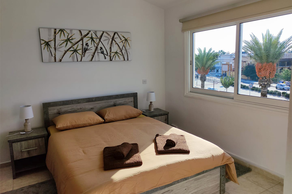 В спальне стояла большая двуспальная кровать, а из окна мы смотрели на пальмы. Источник: airbnb.ru